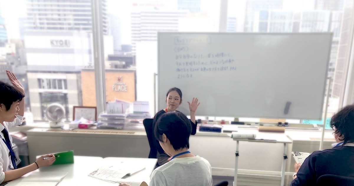 窓際のホワイトボード前で行われている少人数の講義風景