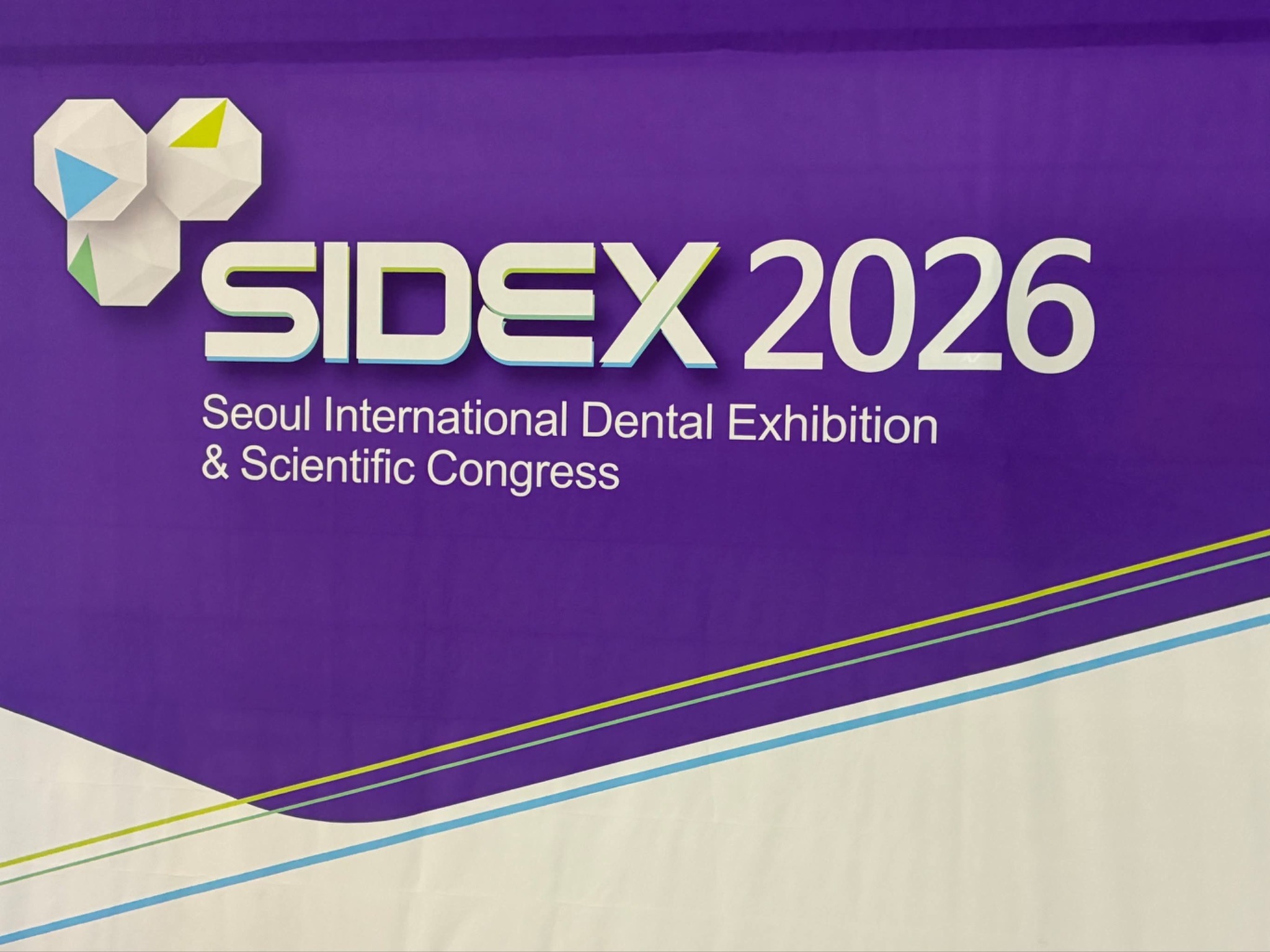 紫色の背景に「SIDEX 2026 Seoul International Dental Exhibition & Scientific Congress」と書かれた看板