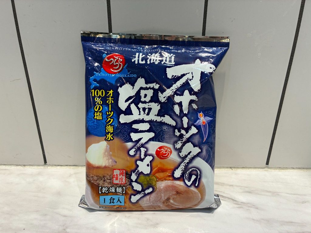 「オホーツクの塩ラーメン」のパッケージ。青い袋に乾燥麺1食入と書かれ、塩ラーメンの盛り付け例が載っている
